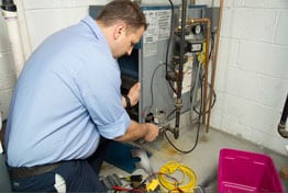 technician fixing a furnace