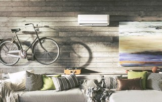 Modern room with wall art and bike hanging above couch with ductless split system