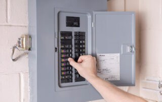 Electrician inspecting an electrical panel for safety and efficiency in a West Allis home.